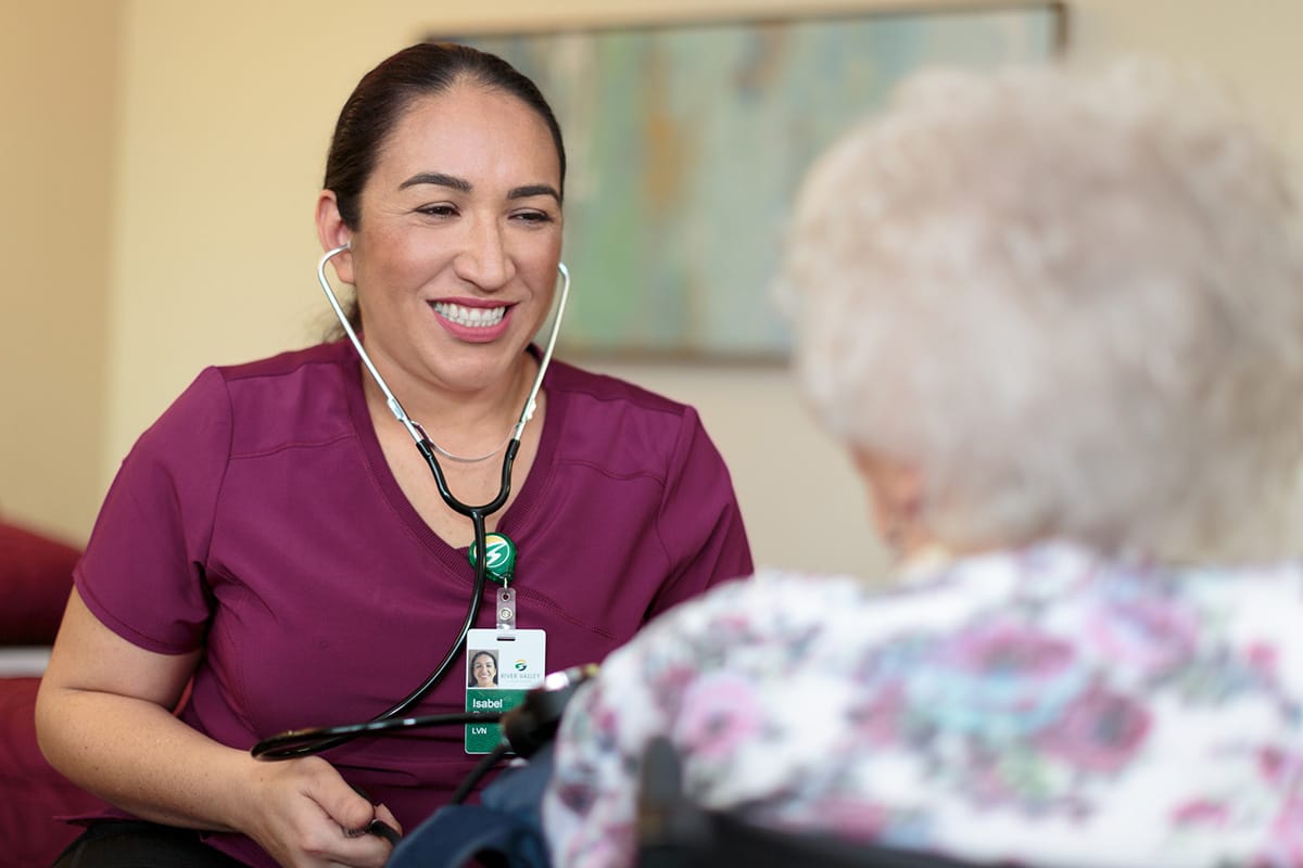 A nurse with an elderly woman at River Valley