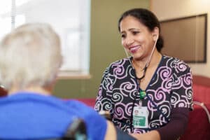 A nurse assisting an elderly woman at River Valley