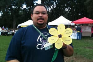 A man holding a paper flower at River Valley