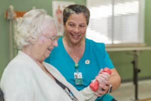A physical therapist helping an elderly woman at River Valley